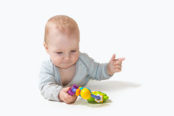 istock Baby boy is lying on white background holding a toy. 1202069600