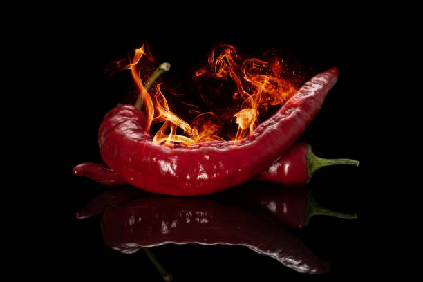 istock Burning hot pepper isolated on black glass 1202070139