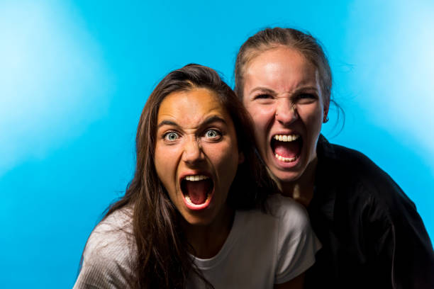 istock Two Women Looking at Camera and Screaming on Blue Background 1202071705