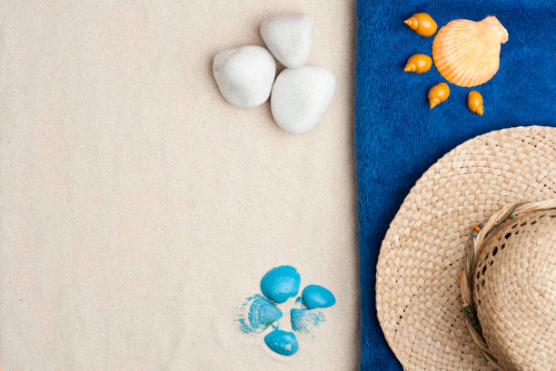 istock Summer time concept with seashells, blue and orange shells, pebbles, straw hat, on white sand background 1202081888