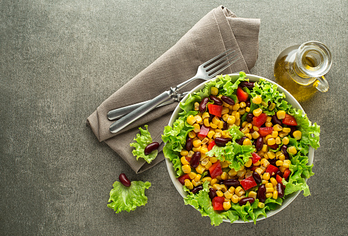 Healthy Green salad with corn and beans on grey background. Mexican corn salad.