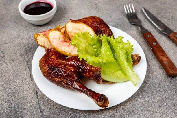 istock Roasted duck leg with apples on a plate. Close-up. 1202084378