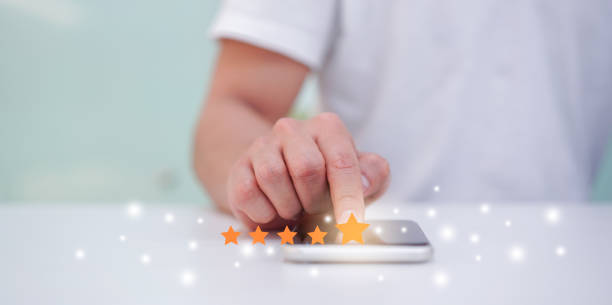 close up on customer man hand pressing on smartphone screen with  five star rating feedback icon and press level excellent rank for giving best score point to review the service , technology business concept