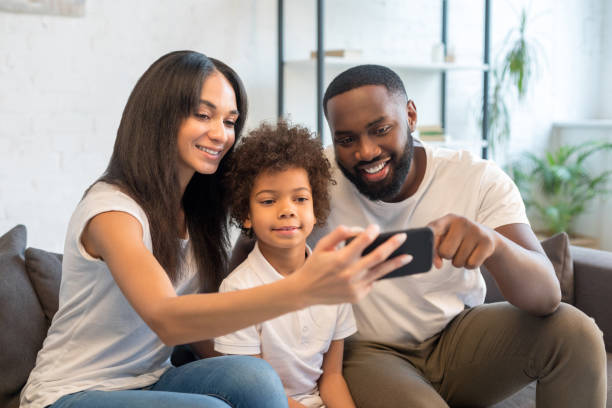 istock Happy young family using mobile phone at home 1202087899