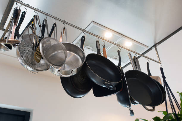 istock Stainless steel cookware , kitchenware set hanging on a rack on the wall, frying pans and saucepan in modern home 1202088125