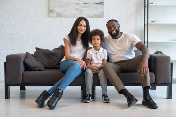 istock Happy family sitting on sofa at home 1202088309