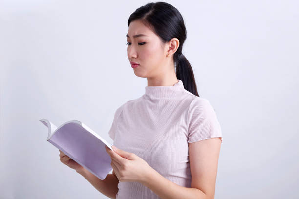 istock young chinese woman reading book 1202088319