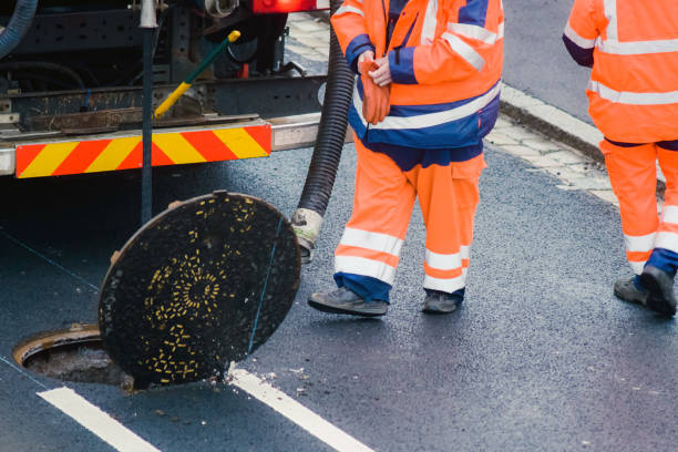 istock workers cleaning and maintaining the sewers on the roads 1202088607
