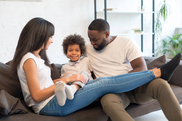istock Smiling parents playing with their little son at home 1202088749