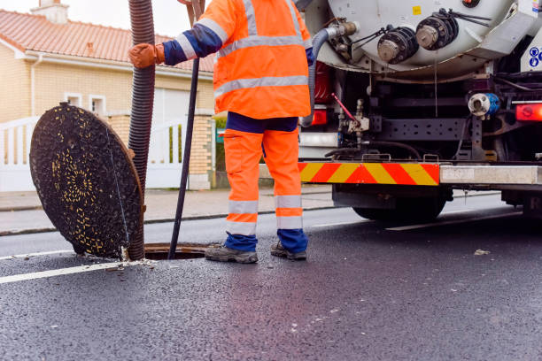 道路上の下水道を清掃し、維持する労働者 - マンホール ストックフォトと画像