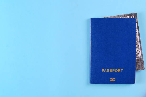 istock Blue external passport with airplane ticket inside on the bright blue background. Photo with a copy space 1202091244