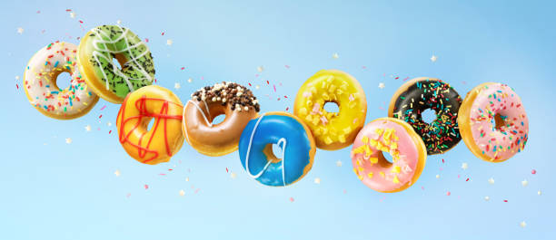 istock Various colorful doughnuts in motion on blue background 1202092040