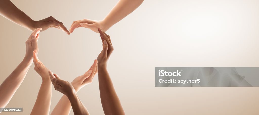 The concept of unity, cooperation, teamwork and charity. Symbol and shape of heart created from hands.The concept of unity, cooperation, partnership, teamwork and charity. Heart Shape Stock Photo