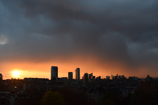 Silhouette of Brussels city at sunset under grey clouds