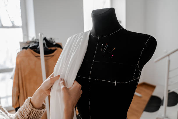 Hands that sort through the fabric. Mannequin with fabric on the shoulder and stuck pins into the fabric in design studio for sewing and tailoring, special education concept manos que atraviesan la tela. maniquí con tela en el hombro y pasadores pegados en el estudio de diseño en el estudio de diseño para coser y sastrenear, concepto de educación especialmanos que se clasifican a través de la tela. maniquí con tela en el