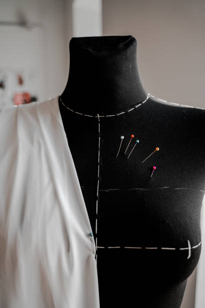 istock Mannequin with fabric on the shoulder and stuck pins into the fabric in design studio for sewing and tailoring, special education 1202097319