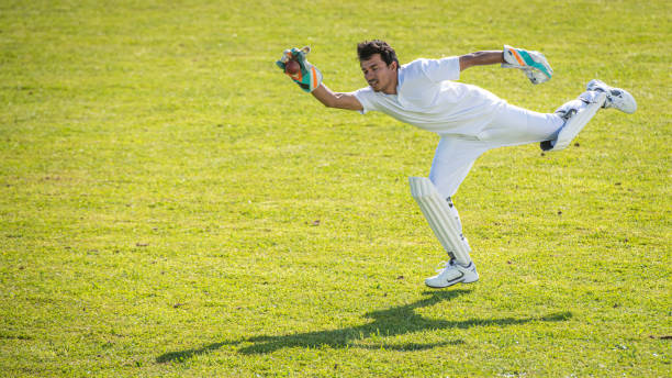 istock Indian cricket player in mid-air catching the ball 1202097483