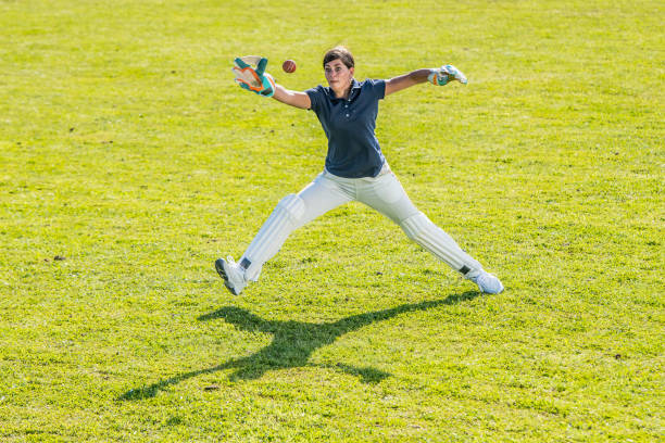istock Female cricket player moments before catching the ball 1202097504