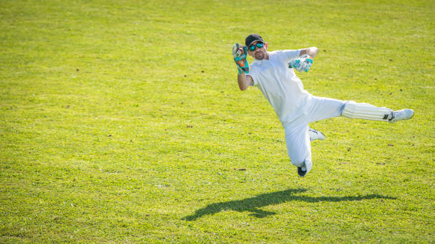 istock Cricket player in mid-air while catching the ball 1202097515