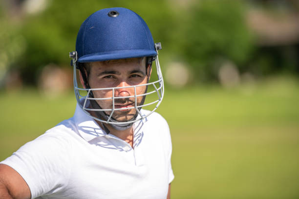 Cricket batsman holding a bat and helmet