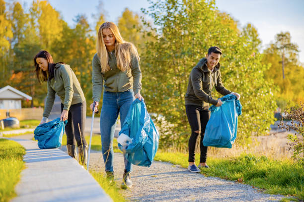 istock Young volunteers picking up garbage in bag at park 1202097562