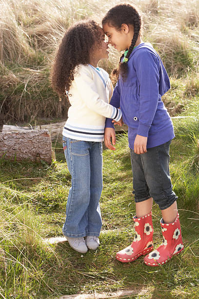 Young Girls Having Fun Playing In Field Together