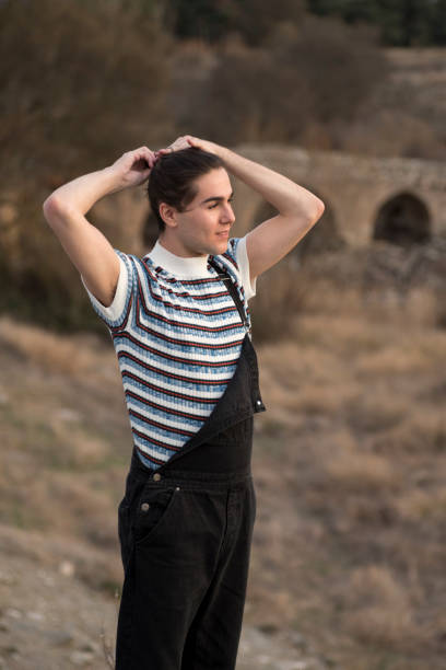 istock Young man posing in the field and with a bridge 1202099872