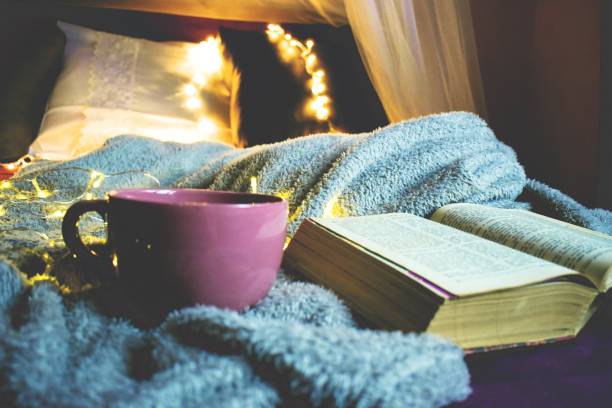 istock Big coffee mug and a book on a gray blanket 1202100291