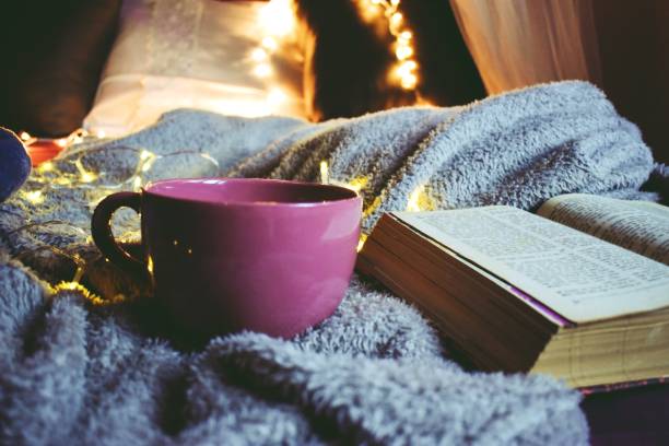 istock Big coffee mug next to a book on a gray blanket 1202100814