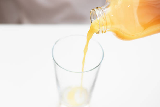 istock Orange juice is poured into a glass. Healthy breakfast. 1202101530