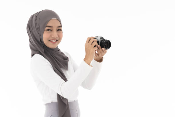 Muslim girl Camera Portrait of happy young adult asian muslim fenale tourist and photographer holding a camera and smiling. Studio shot of woman isolated on white background muslim photographer stock pictures, royalty-free photos & images