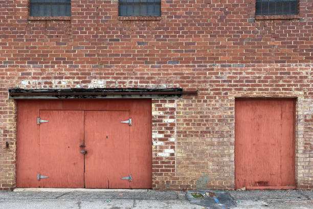 an abandoned warehouse alley brick wall with red doors