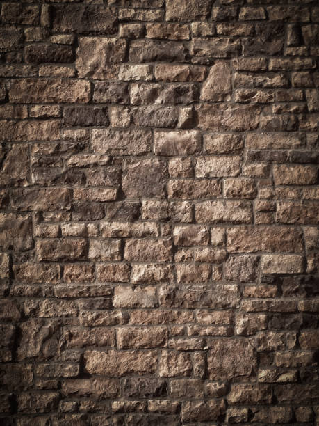 istock Dark Rough Monochrome Brick Wall Background With Vignette 1202104019