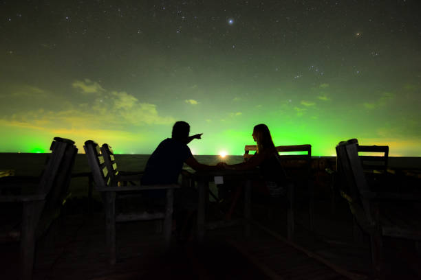 Table for two Couple keeping their hands under the nightsky in an exotic island of Thailand. stars in your eyes stock pictures, royalty-free photos & images