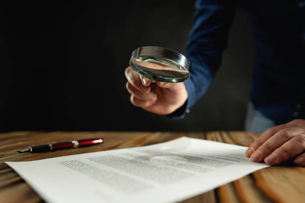 istock Businessman Reading Contract Using Magnifying Glass Before Signing 1202110040