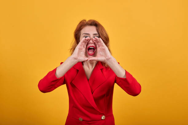 istock Young woman keeping hands ear face, screaming, announcing something 1202111370