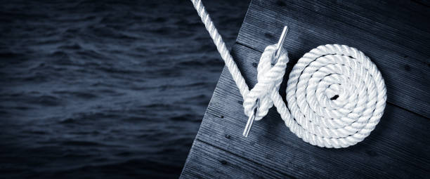 boat rope secured to cleat on wooden dock - equipamento náutico imagens e fotografias de stock