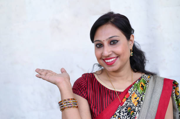 istock Happy woman pointing on white wall 1202111902
