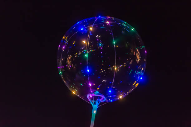 istock A transparent balloon glows with lamps different colors on black 1202113996