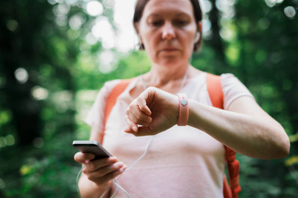 istock Female hiker checking fitness tracker wristband data 1202114271