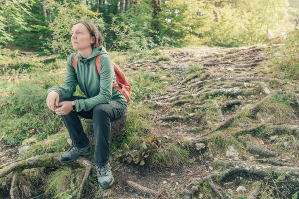 istock Female hiker resting and contemplating in forest 1202114348