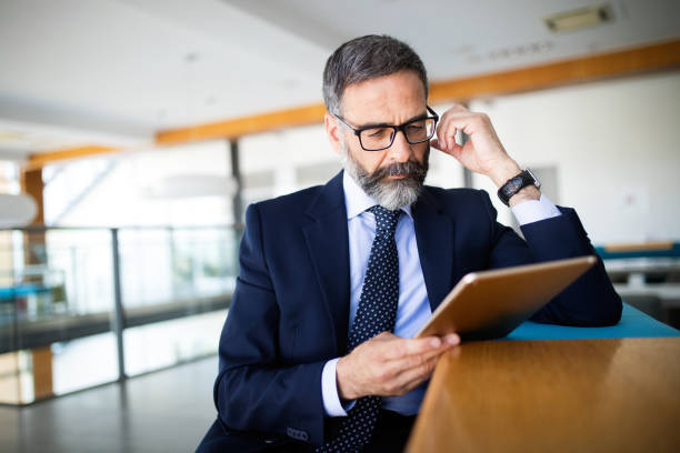 istock Mature handsome business man using a digital tablet at office 1202114906