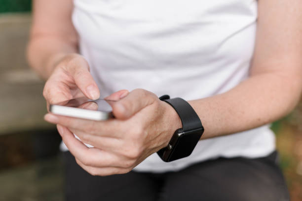 istock Female hiker using smartphone and smart watch 1202114952