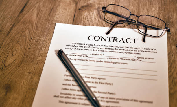 hoja de contrato con gafas y bolígrafo sobre fondo de madera - contract signing document legal system fotografías e imágenes de stock
