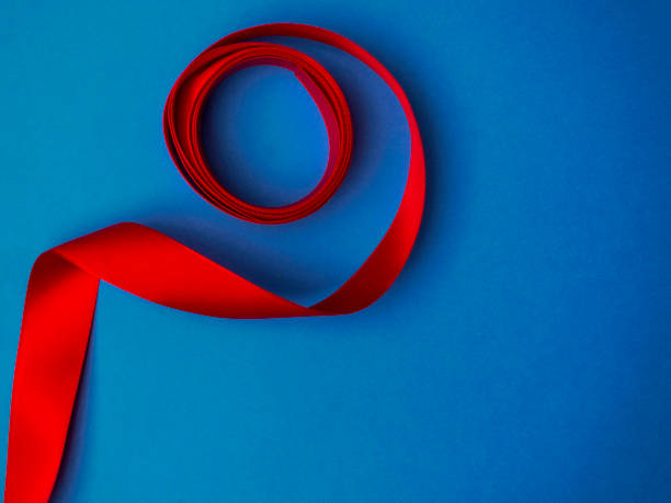 istock red silk ribbon twisted on a trendy classic blue background, festive postcard, copy space 1202115592