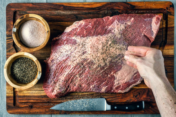 Seasoning a Brisket Seasoning a beef brisket with salt and pepper before barbequing on a smoker brisket photos stock pictures, royalty-free photos & images