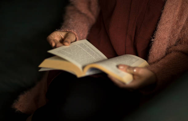istock Young woman reading book at home leisure 1202116783