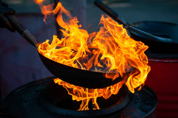 istock Chef cooking with fire in frying pan 1202117577