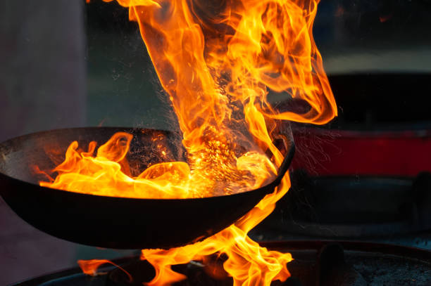 istock Chef cooking with fire in frying pan 1202117586