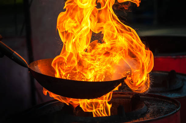 istock Chef cooking with fire in frying pan 1202117589